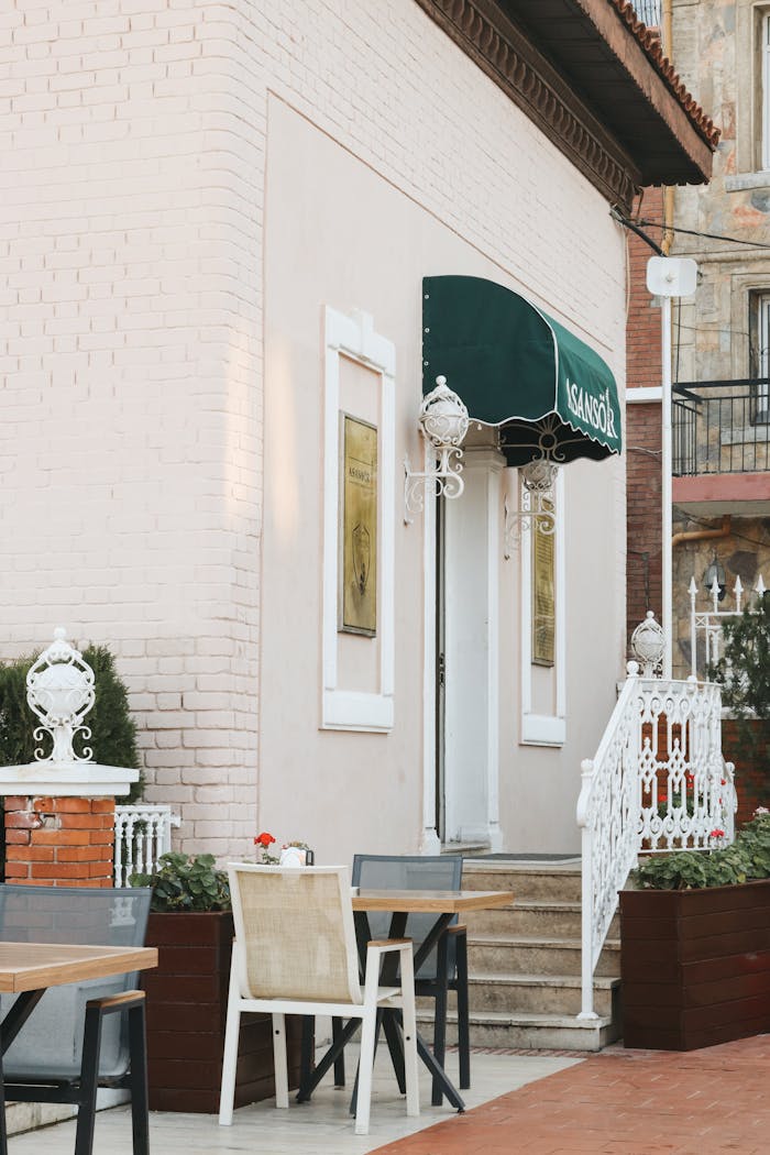 A quaint café exterior with stylish outdoor seating and decorative elements.